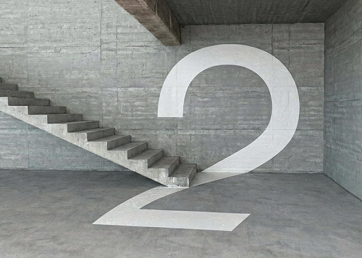 A white numeral 2 extends from a concrete wall onto the floor beside stairs